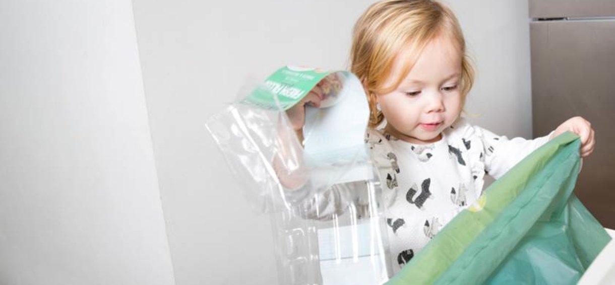 Een klein kind helpt bij het plastic afval scheiden